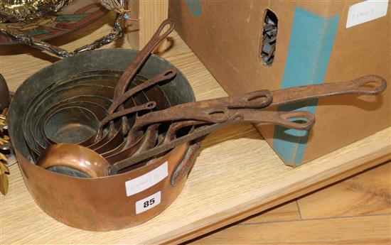 A set of graduated copper saucepans